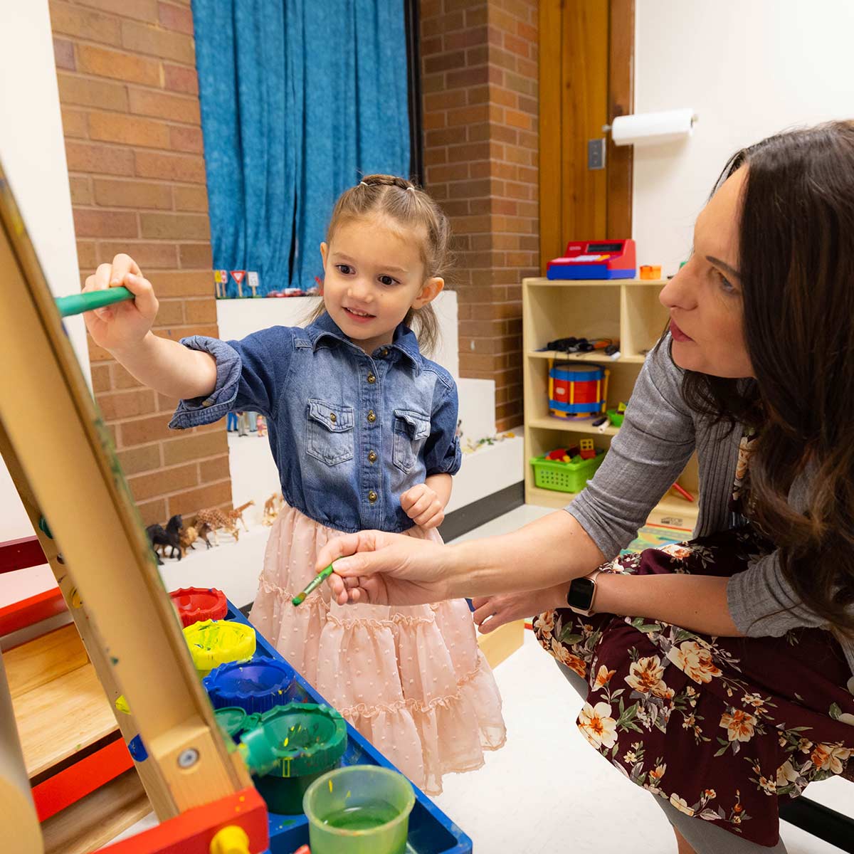 A counselor paints with a child during a therapy session at the counseling clinic.