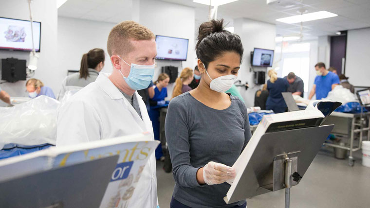 Student and professor reviewing a textbook inside McQueary Health Science Hall.