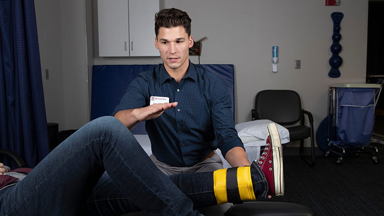 A professor taking care of a patient's ankle. 