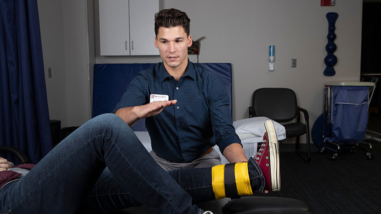 Professor taking care of a patient's ankle.